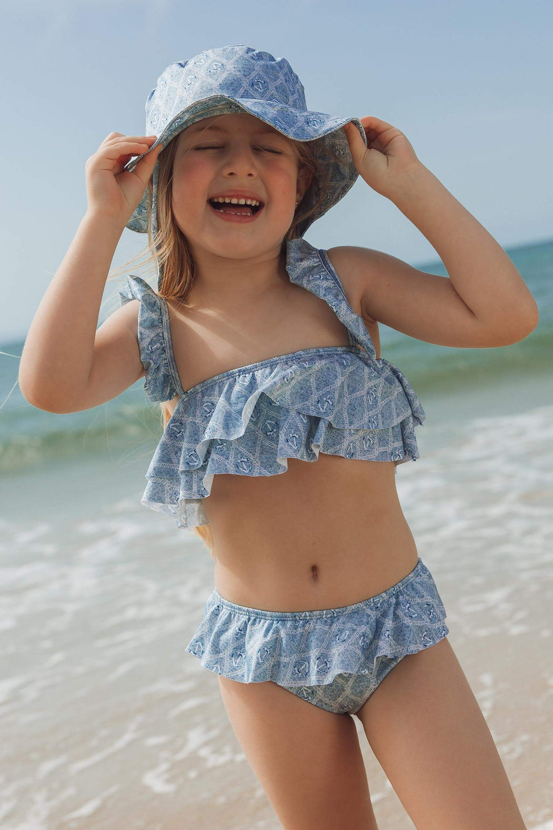 Biquininho de praia com babados e chapeuzinho combinando na estampa âncora