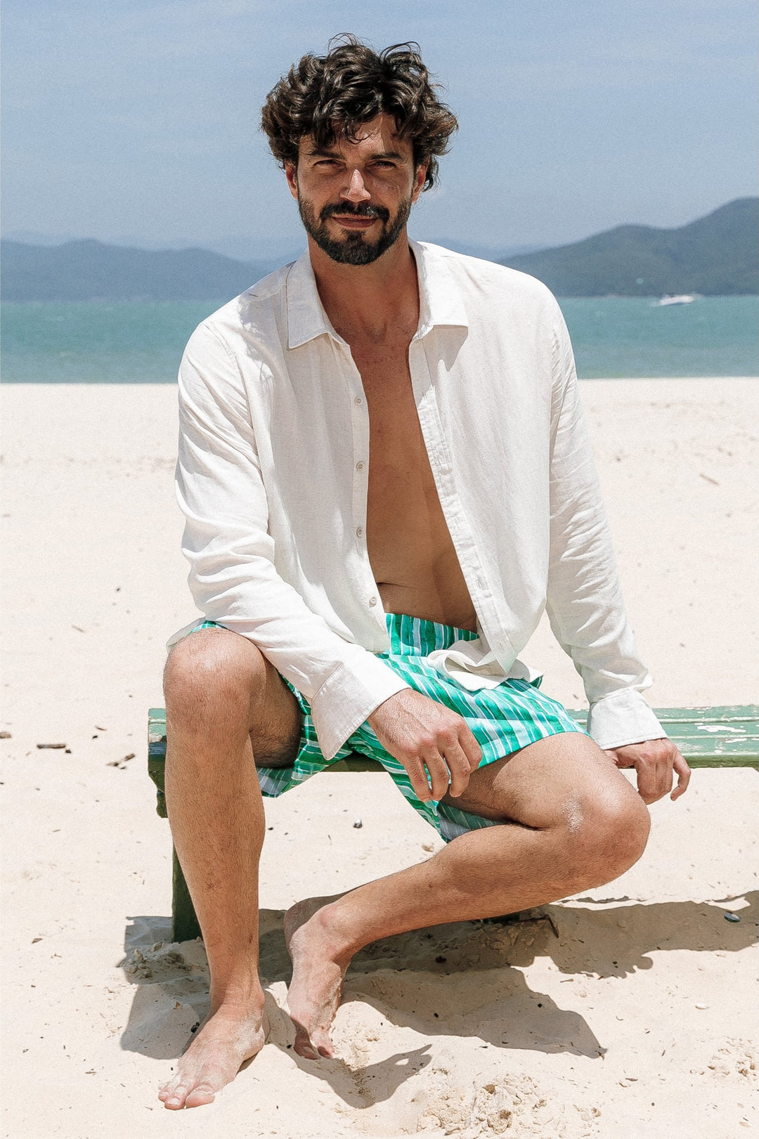  Conjunto Moda Praia. Short Masculino são perfeitos para os dias quentes. Combine-os com Camisa de Linho, fresca e leve, com mangas longas e botões, para um estilo casual e elegante em qualquer estação. Na Estampa, Listras Verdes, da Lili Sampedro.