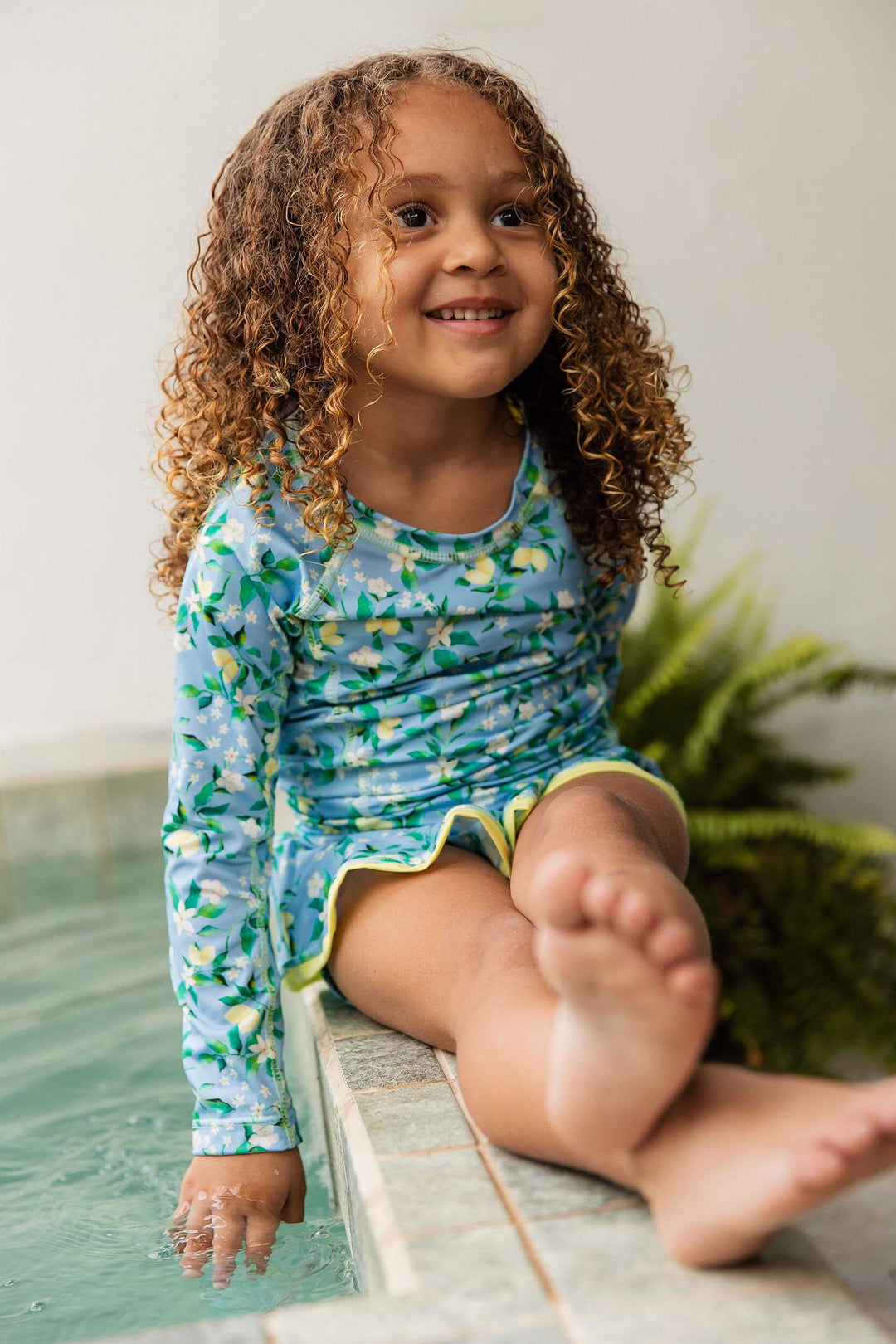 modelo usando maiozinho de alcinha com camiseta UV infantil na piscina, na estampa exclusiva da Lili Sampedro Limões