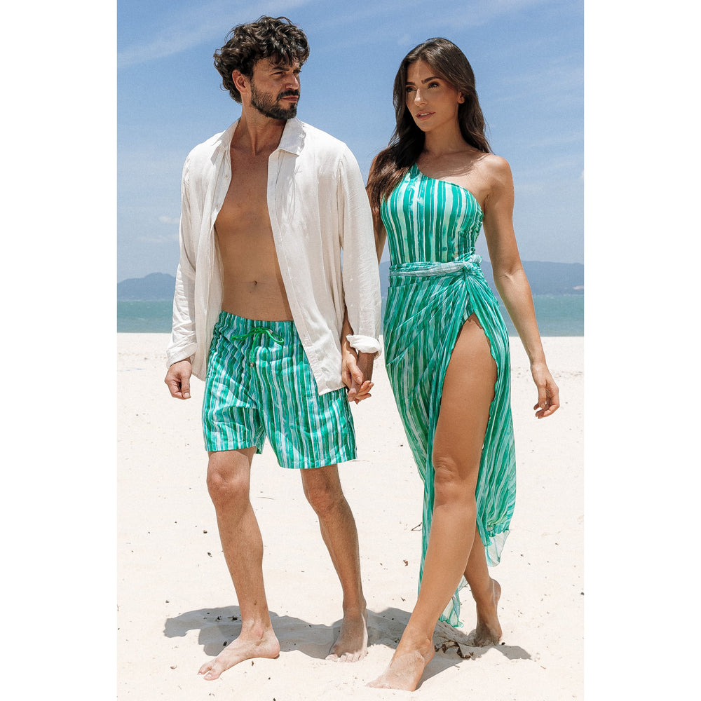 Estilo Perfeito para Casais na Praia com Look Combinando. Shorts Masculinos para adultos são ideais para os dias quentes, bolsos práticos e design versátil. Completando o visual com Saída de Praia em Tule, proporcionando leveza e elegância. Aproveite o verão com conforto e estilo. Na Estampa. Listras Verdes, da Lili Sampedro.