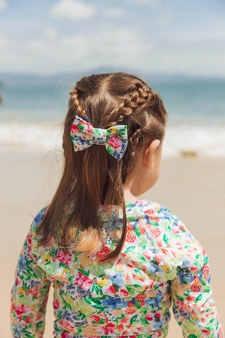 bebê usando lacinho de cabelo combinando com a camisetinha UV de praia