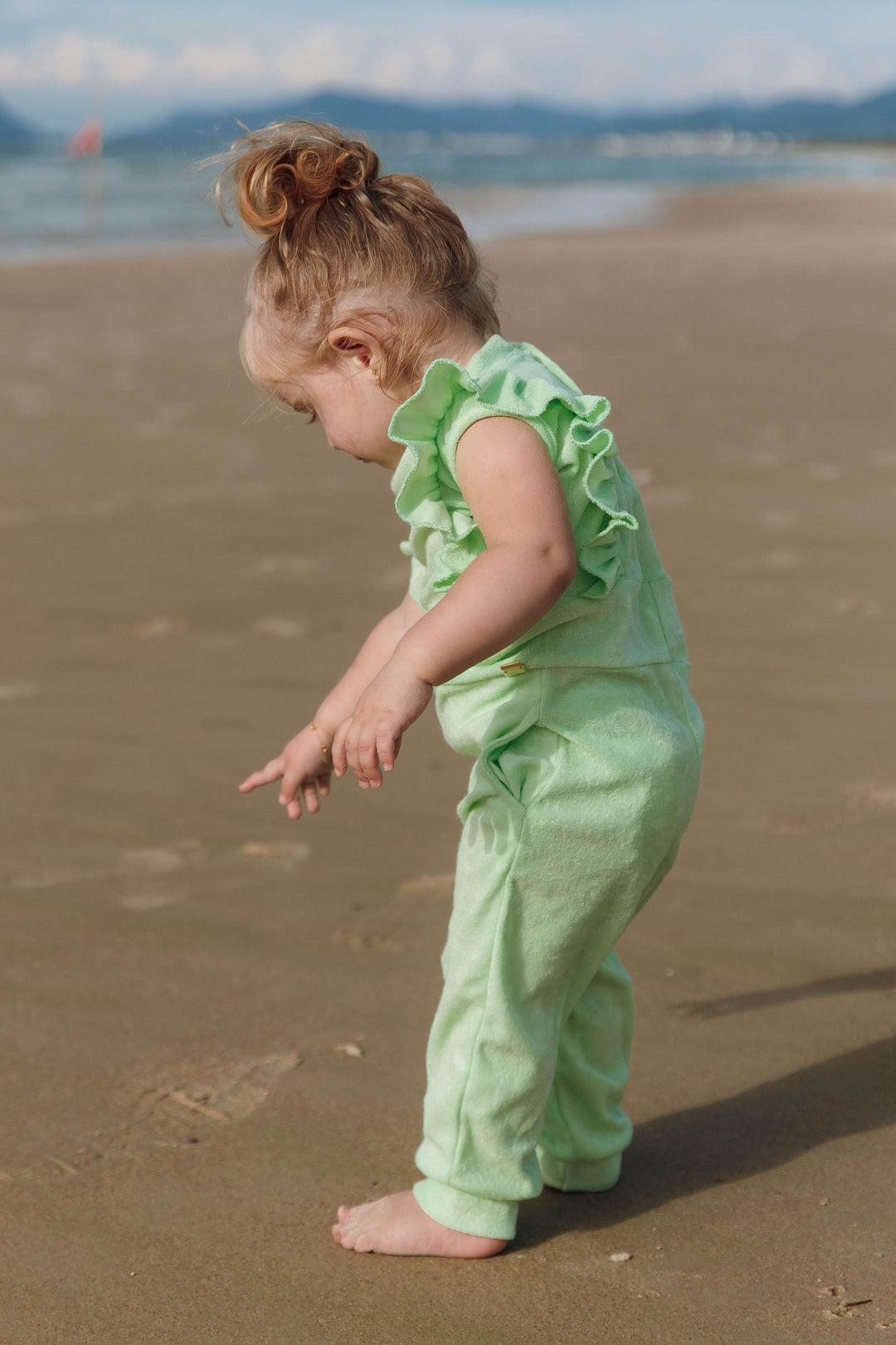 Moda Praia para Bebês, curta os dias de sol com nosso macaquinho infantil em malha atoalhada. Modelo regata com encantadores babadinhos nas alças, bolsos frontais e prático fechamento nas costas com botões de pressão. Macio ao toque, é o companheiro ideal para os pequenos na praia. Na Cor Verde Claro, da Lili Sampedro.