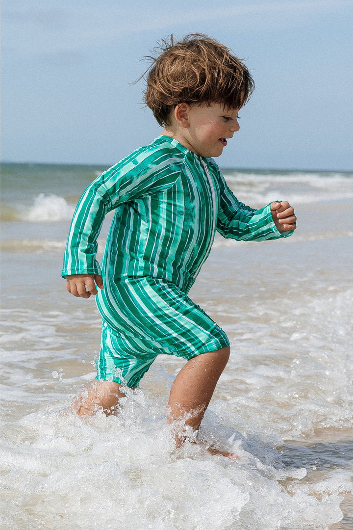 Roupas de Banho para Bebês, Macaquinho para os Dias de Diversão, Enquanto Criam Memórias Inesquecíveis Na Praia. Na Estampa Listras Verdes, da Lili Sampedro.