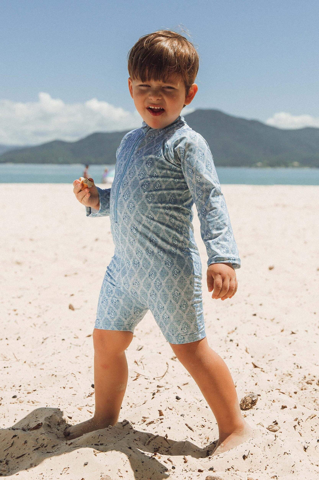 Modelo na praia usando macaquinho de praia infantil masculino na estampa exclusiva da Lili Sampedro, Âncora