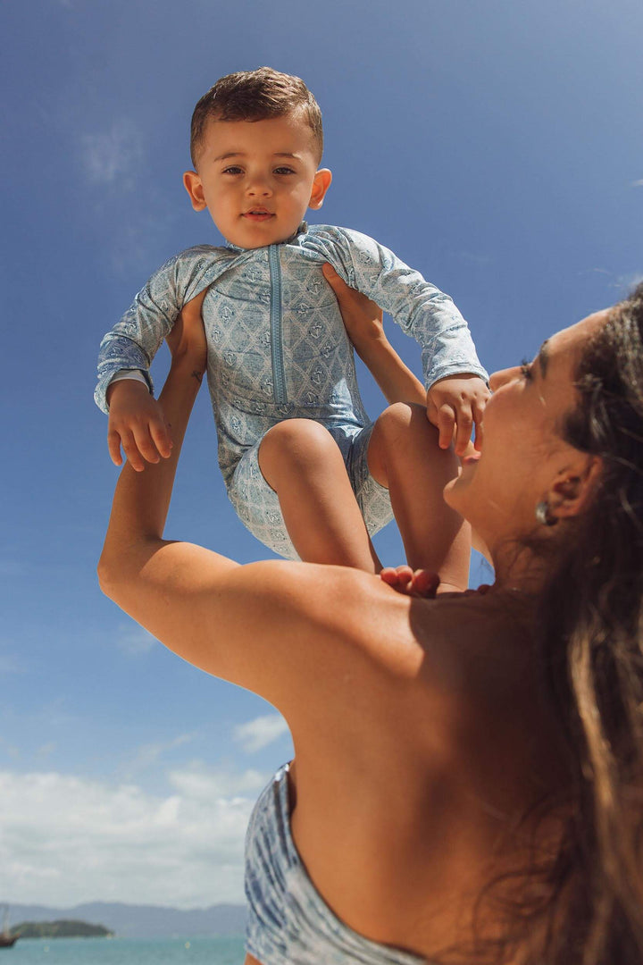 Modelo vestindo biquini combinando com macaquinho infantil na praia, estampa Âncora da Lili Sampedro