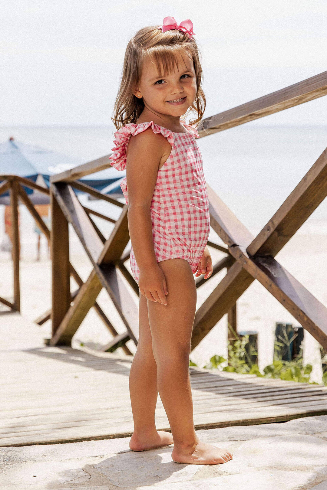 Bebê com o Maiozinho Infantil Feminino de Praia com Babadinhos, na Estampa Vichy Rosa, da Lili Sampedro.