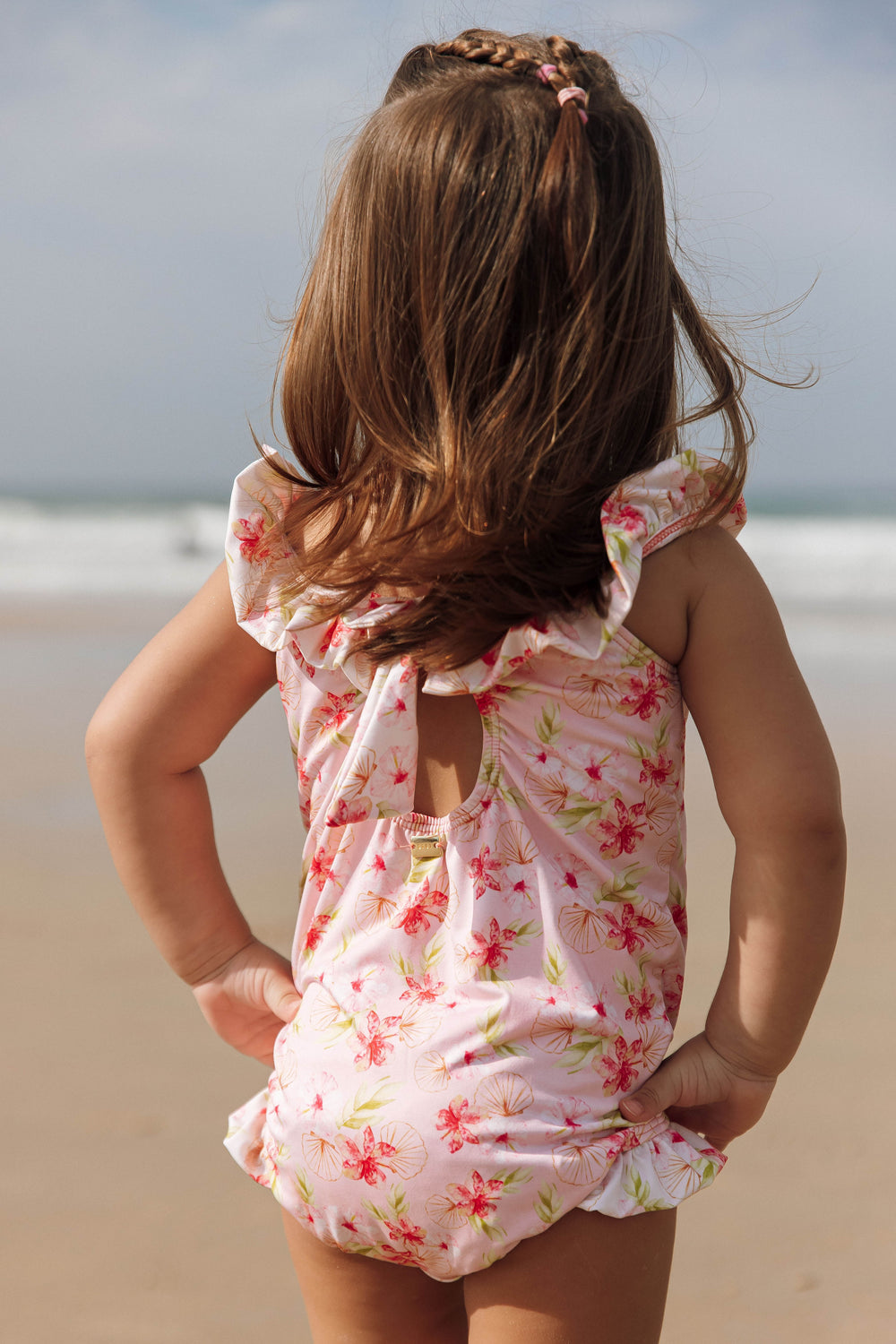 Bebê com o Maiozinho Infantil Feminino de Praia com Babadinhos e abertura nas costas, na Estampa Hibiscos, da Lili Sampedro.