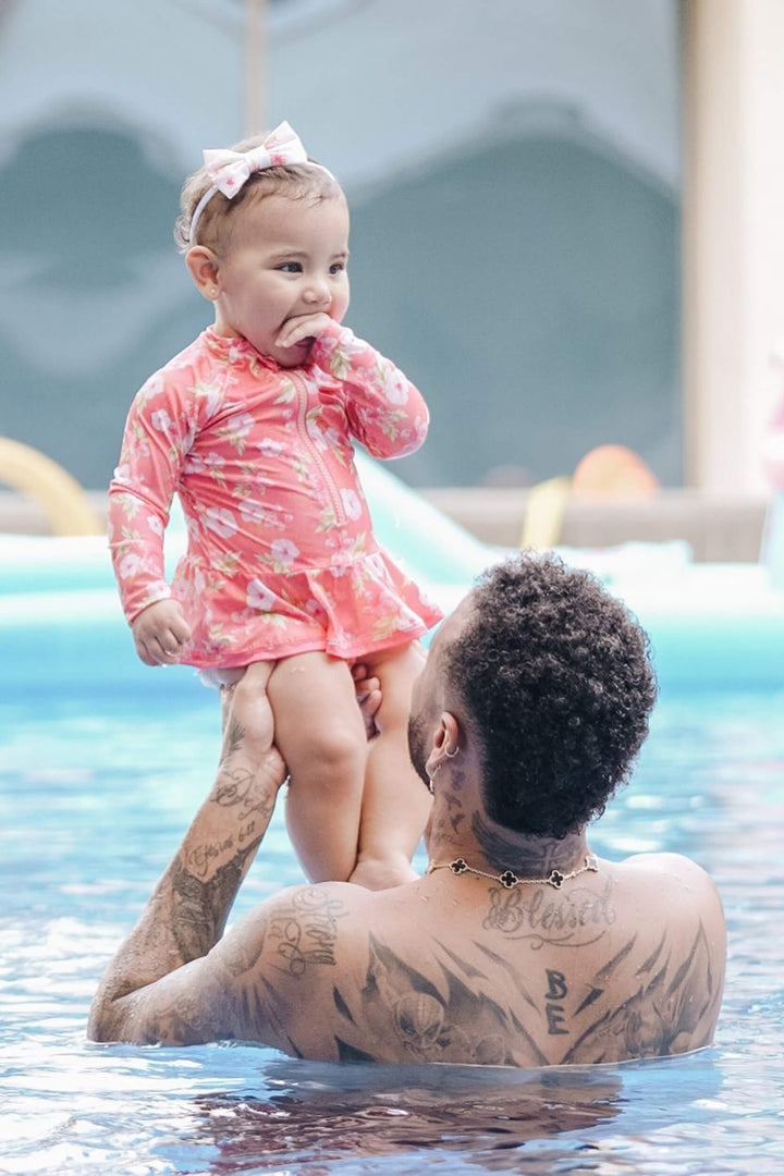 Mavie, filha do Neymar vestindo Maio Infantil de manga longa com proteção UV, na estampa exclusiva de Hibiscos na versão Coral.