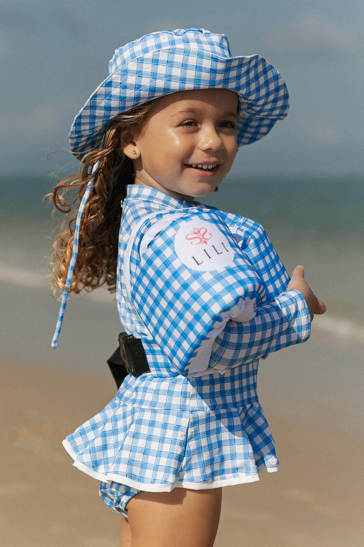 Look de moda praia com chapéu e maio combinando com proteção uv e boia na estampa Vichy Azul