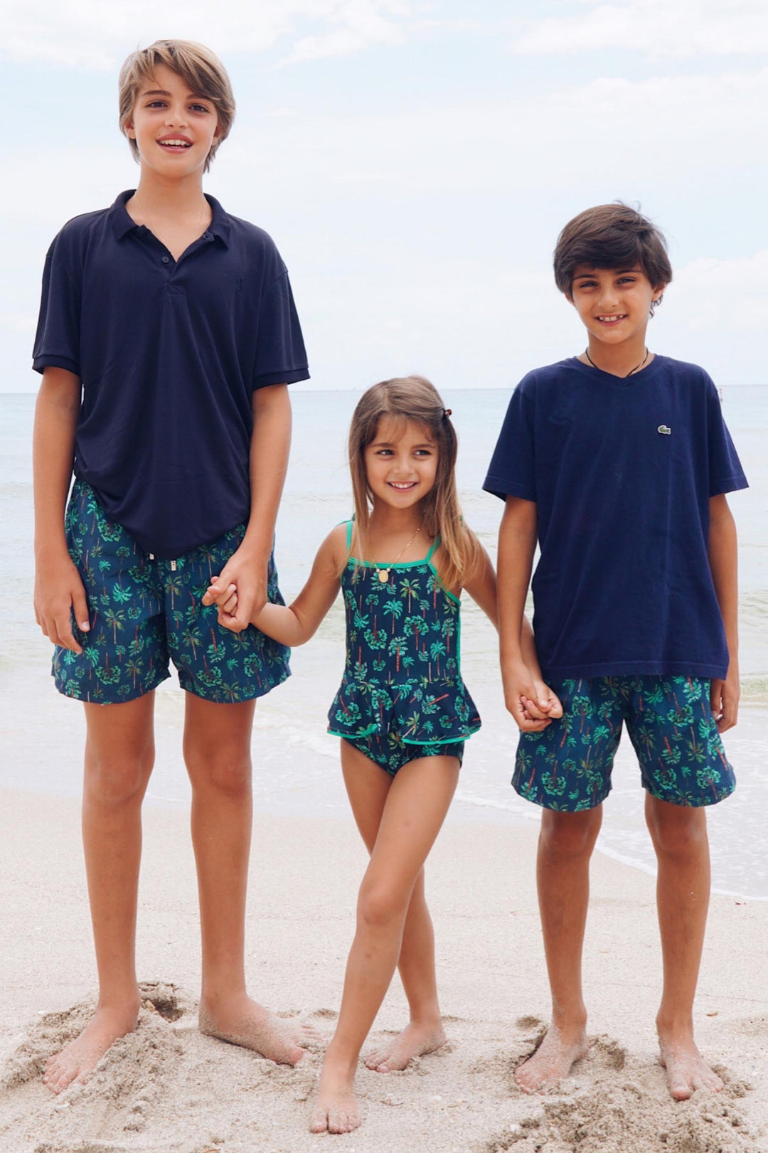 Roupas de praia para crianças combinando, com short infantil e maio infantil na mesma estampa coqueiros azul marinho