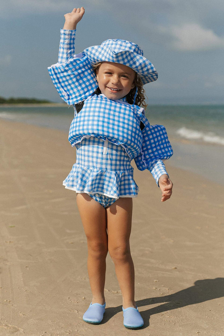 Modelo com look de praia na estampa Xadrez Azul com chapeu, sapatinho neoprene, maio e boia