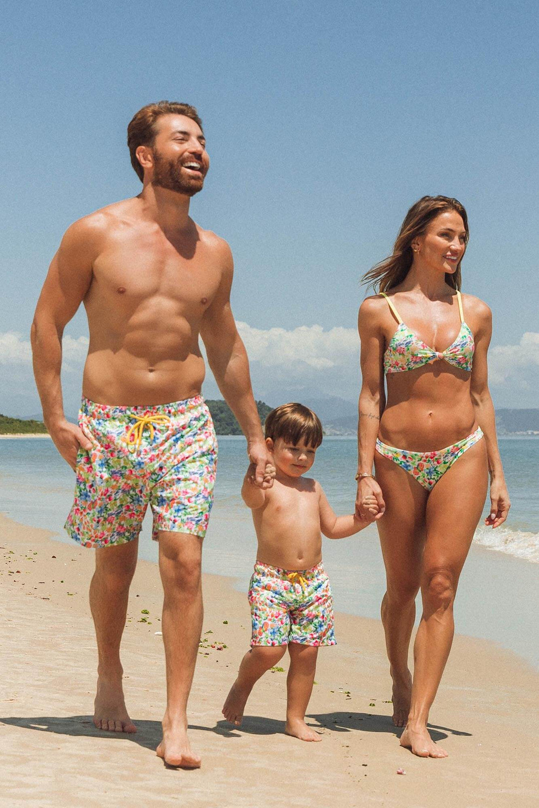 Família na praia vestindo roupa de banho combinando em estampa exclusiva da Lili Sampedro