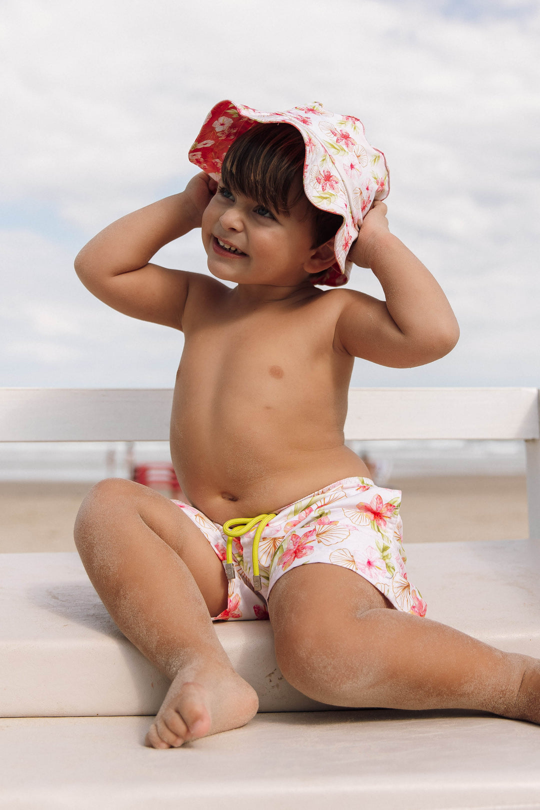 Moda Praia Infantil Masculino, look perfeito para crianças, permite criar opções para usá-lo. Chápeuzinho Dupla Face com Proteção UV, garantindo liberdade de movimento e estilo para os pequenos aproveitarem cada momento da Praia, combinando com short com fechamento por velcro, ajustável por cordão e bolsos funcionais, Feito na nossa estampa exclusiva, Hibiscos da Lili Sampedro.