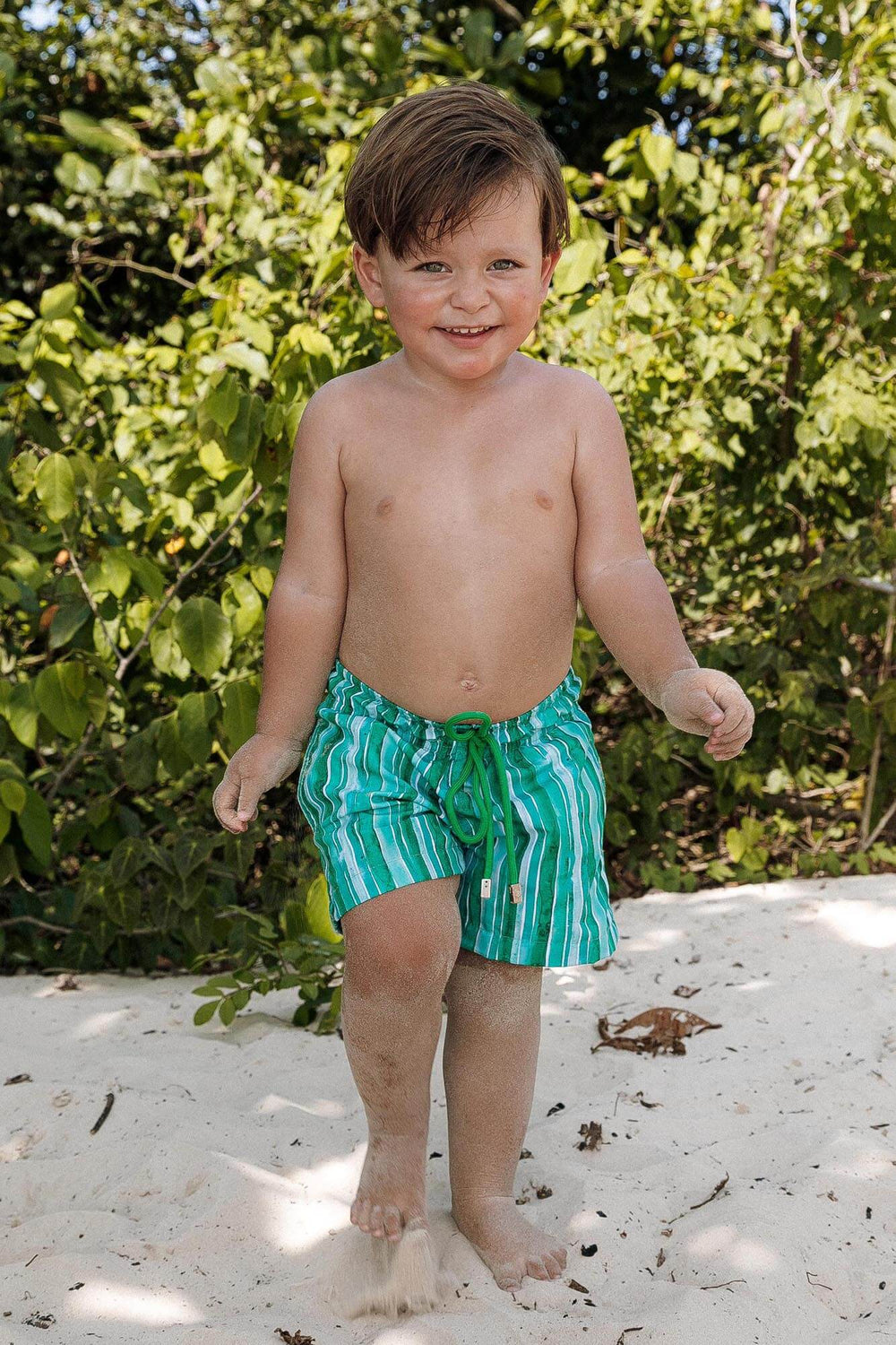 Shorts Masculinos Infantil para Praia, ideais para os dias quentes do verão. Com cós de elástico ajustável por cordão, praticidade para os pequenos aproveitarem ao máximo seus momentos à beira-mar. Na Estampa, Listras Verdes, da Lili Sampedro.