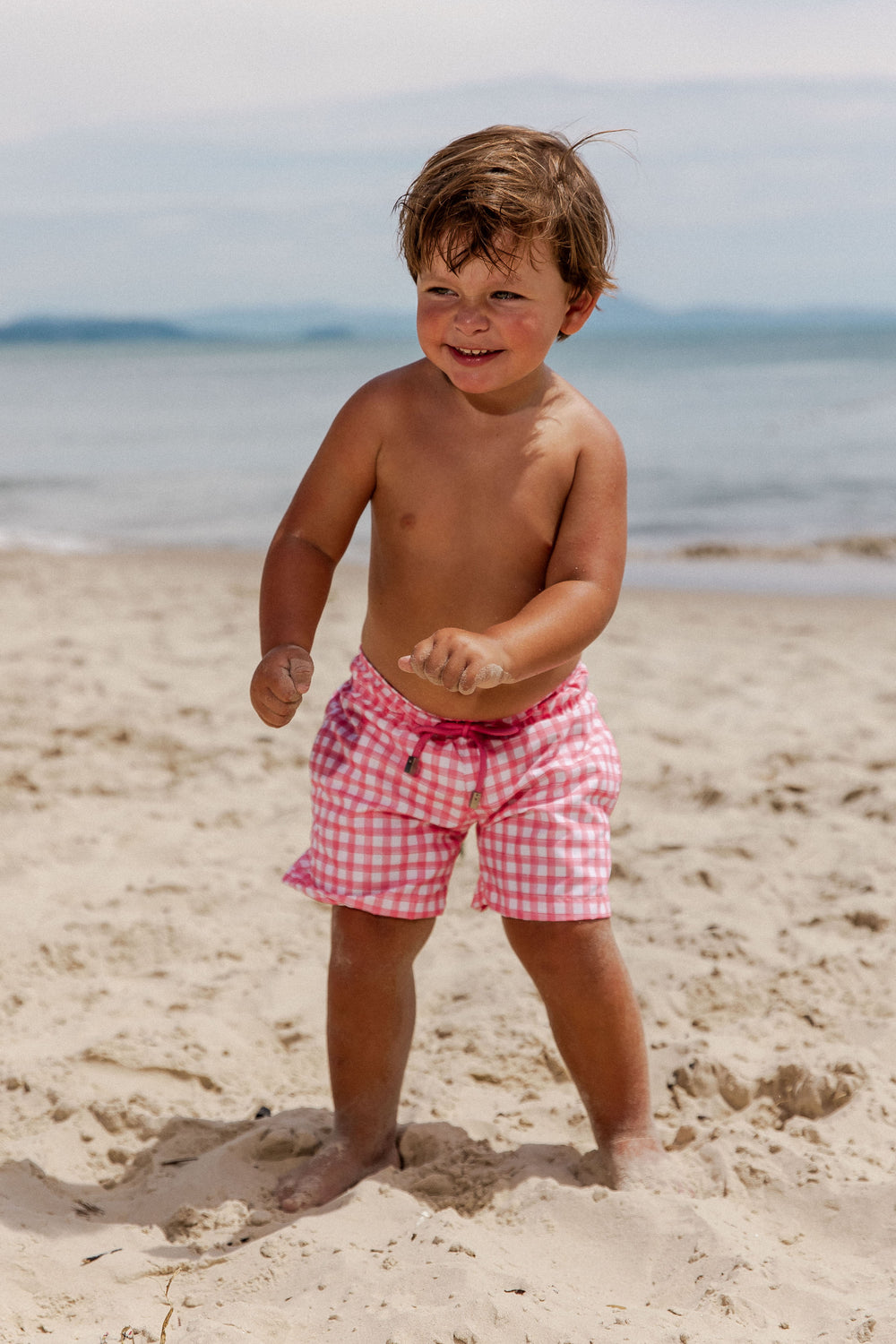 Bermuda de Praia para Meninos, para idades de 6 meses a 14 anos. Com Bolsos Frontais, este short proporciona conforto e praticidade, para curtirem momentos de diversão, na praia. Na Estampa, Vichy Rosa, da Lili Sampedro.