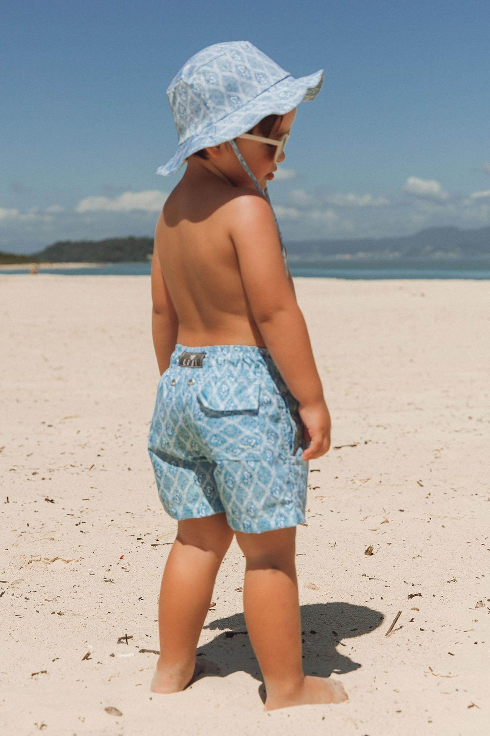 Modelo usando short de praia infantil e chapéu combinando da estampa exclusiva Âncora 