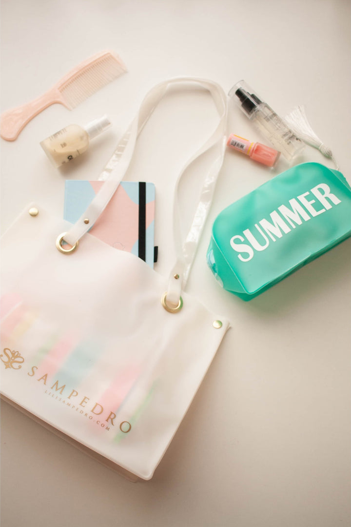 Bolsa de Praia ou Piscina Aprova D'Agua Feita de Silicone na Cor Branca, na Foto com Necessaire Verde Agua com escrito Summer, da Colecao de Accesorios de Praia da Lili Sampedro